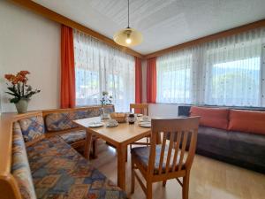 a living room with a table and a couch at Apartment Kraftreich Apartments-4 by Interhome in Aschau