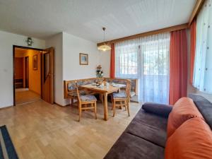 a living room with a table and a couch at Apartment Kraftreich Apartments-4 by Interhome in Aschau