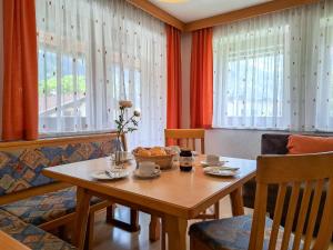 a dining room with a table and chairs and windows at Apartment Kraftreich Apartments-4 by Interhome in Aschau