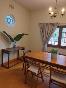 a dining room with a table and chairs and a window at Muizenberg Surfers Lodge in Muizenberg