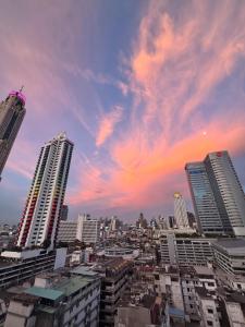 a city skyline with tall buildings and a cloudy sky at Bangkok Prime Location Residence in Makkasan