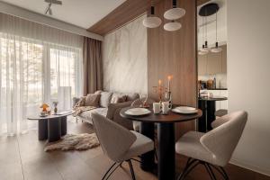 a living room with a couch and a table and chairs at Willa Zieleniec - apartamenty z Ogrodem SPA in Duszniki Zdrój