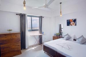 a bedroom with a bed and a dresser and a window at Skyline Views Pool access Central Location in Yakbedda +65 photos
