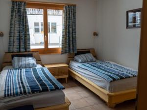 two beds in a room with a window at Apartment Alpine Retreat by Interhome in Adelboden