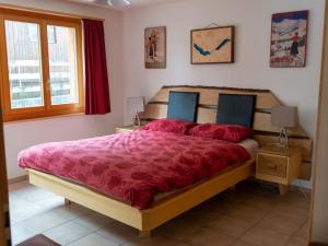 a bedroom with a large bed with a red comforter at Apartment Alpine Retreat by Interhome in Adelboden