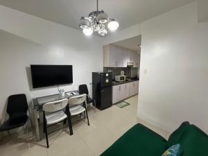 a living room with a table and chairs and a television at Sea Residences in Manila