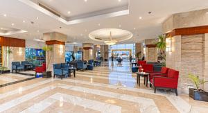 a lobby of a hotel with red chairs and tables at Xperience Sea Breeze Resort in Sharm El Sheikh +151 photos