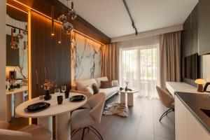 a living room with a table and a couch at Willa Zieleniec - apartamenty z Ogrodem SPA in Duszniki Zdrój