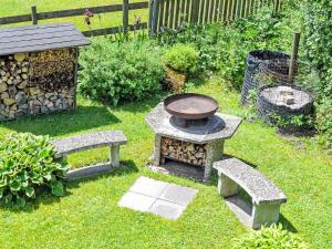 a backyard with two benches and a grill in the grass at Apartment Bella Vista by Interhome in Sörenberg