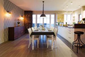a dining room with a table and chairs in a kitchen at SunCliff Lodge - exklusive private Sauna, Sanarium, Kamin und Meerblick in Dranske +33 photos