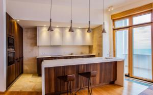 a kitchen with a counter with two stools at Luxury Seafront Villa Rezevici in Reževići