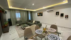 a living room with a couch and a table and chairs at Appartement Meublé HS Bonanjo in Douala