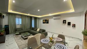 a living room with a couch and a table and chairs at Appartement Meublé HS Bonanjo in Douala