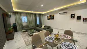 a living room with a couch and a table and chairs at Appartement Meublé HS Bonanjo in Douala