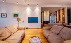 a living room with two couches and a tv at Luxury Seafront Villa Rezevici in Reževići
