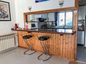 a kitchen with a counter and two stools at a bar at Holiday Home Casa Blumer by Interhome in Les tres Cales