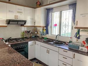 a kitchen with white cabinets and a sink and a window at Holiday Home Casa Blumer by Interhome in Les tres Cales