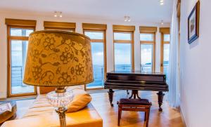 a lamp and a piano in a room with windows at Luxury Seafront Villa Rezevici in Reževići +42 photos