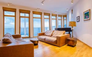 a living room with a couch and some windows at Luxury Seafront Villa Rezevici in Reževići