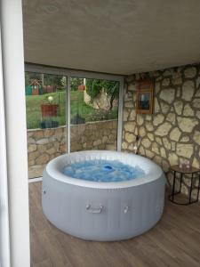 a large white tub in a room with a window at Vikendica Miličin Konak in Vrdnik