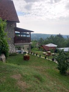 a house on a hill with a table and an umbrella at Vikendica Miličin Konak in Vrdnik