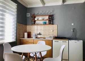 a small kitchen with a white table and chairs at Ryn Lake Resort 2 in Ryn +9 photos
