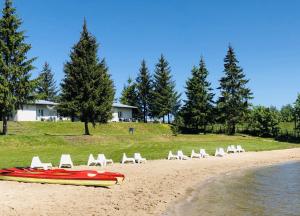 a group of chairs and a boat on a beach at Ryn Lake Resort 2 in Ryn