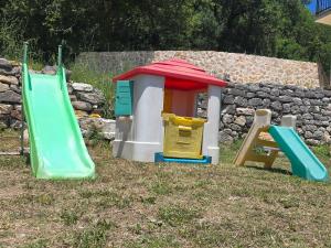 a playground with two slides and a play house at Rustic house in Bar