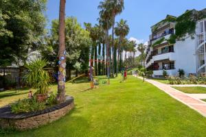 a park with palm trees and a building at Club Titan Hotel Ultra All Inclusive in Kargicak