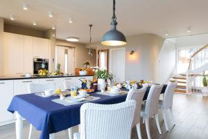 a dining room with a blue table and chairs at SunCliff Lodge - exklusive private Sauna, Sanarium, Kamin und Meerblick in Dranske