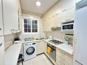 a kitchen with a washing machine and a sink at Consell Habitaciones in Barcelona