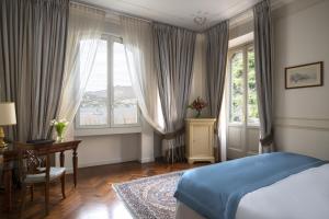 a bedroom with a bed and a desk and a window at Albergo Terminus in Como