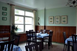 comedor con mesa, sillas y ventana en Pension Bajamar, en Ladrido