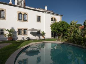 a swimming pool in front of a house at Villa Vasco da Gama in Cascais
