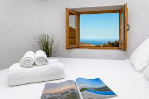 a room with a bed with towels and a window at Campo and relax Málaga country house in Málaga