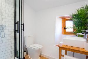 a white bathroom with a toilet and a sink at Campo and relax Málaga country house in Málaga +6 photos