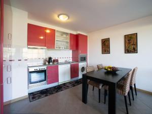 a kitchen with red cabinets and a table with chairs at Apartment Full moon by Interhome in Portimão +26 photos