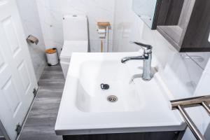a white sink in a bathroom with a toilet at Giraffe House Vilankulo in Vilanculos +64 photos