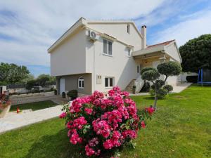 a house with pink flowers in front of it at Holiday Home Karlo by Interhome in Posedarje