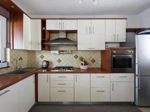 a kitchen with white cabinets and a stainless steel refrigerator at Holiday Home Karlo by Interhome in Posedarje