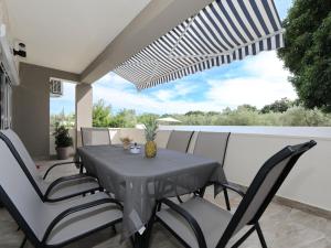 a black table and chairs on a patio with a view at Holiday Home Karlo by Interhome in Posedarje