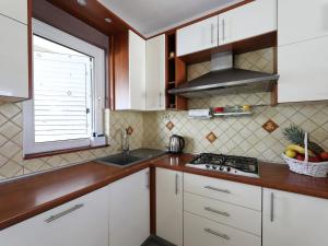 a kitchen with white cabinets and a sink and a window at Holiday Home Karlo by Interhome in Posedarje +45 photos