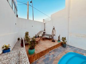 a balcony with a bench and plants on a building at Dar Surfana Surf Camp & Yoga Tamraght in Aourir