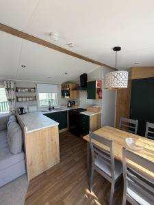 a kitchen and a living room with a table and a kitchen at Inverbeg Holiday Park in Luss