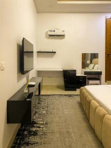a hotel room with a bed and a desk and a bed at Super Star Midak Mews 2 in Lekki