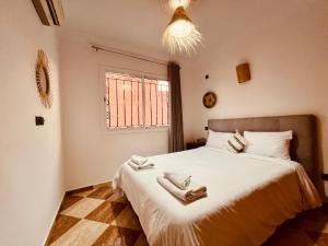 a bedroom with a bed with two towels on it at Dar Surfana Surf Camp & Yoga Tamraght in Aourir +57 photos
