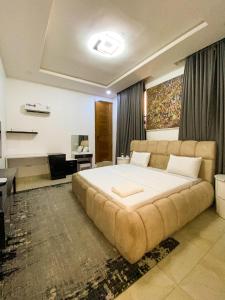 a large bed in a bedroom with a large couch at Super Star Midak Mews 2 in Lekki
