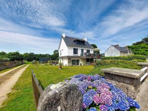 a house with flowers in front of a fence at Apartment Ty PJP by Interhome in Névez