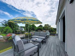 a patio with chairs and a table and an umbrella at Apartment Ty PJP by Interhome in Névez