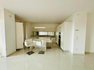 a large white kitchen with a table and chairs at Intero appartamento a pochi passi dalla piazza in Marostica
